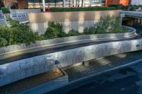 an empty ramp runs through the city as the road goes under it near a parking garage