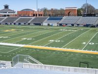 the stadium has an empty field near many seats and stands with a scoreboard on it