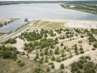 aerial view of landscape, with boat dock and large lake in the distance in rural area