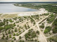 aerial view of landscape, with boat dock and large lake in the distance in rural area