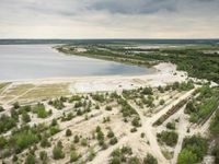 aerial view of landscape, with boat dock and large lake in the distance in rural area