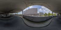 view through circular perspective into concrete buildings and sky line with building in background, from the outside