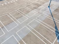 an overhead view looking down at a parking lot with a white crosswalk pattern and a street light