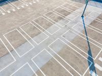 an overhead view looking down at a parking lot with a white crosswalk pattern and a street light