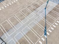 an overhead view looking down at a parking lot with a white crosswalk pattern and a street light