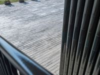 the large black and white bench is near metal pillars and railings in the park