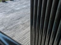 the large black and white bench is near metal pillars and railings in the park