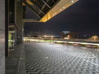 an empty public walkway that looks as if it is outside in the city lit by lights