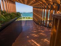 a wooden deck with planters and an ocean view outside the deck area of a home