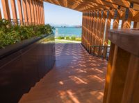 a wooden deck with planters and an ocean view outside the deck area of a home