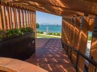 a wooden deck with planters and an ocean view outside the deck area of a home