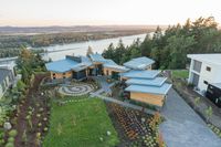 an aerial view of two houses and a large lake, in the distance is a hillside with