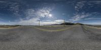 two intersecting roads with a few cars going by on it and a sky background and mountain