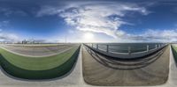 360 - camera captures the intersection of two ramps with sky background and city in background