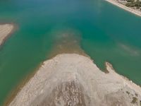 an aerial view of the green water near the land in the distance is a lake that is very calm and clean