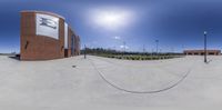 360 - view picture of a large brick building at the edge of a tennis court