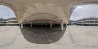 there is a large empty parking lot with many buildings in it and the reflection of the building from the fisheyes