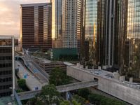 the view from a rooftop in an urban area with skyscrapers and street lights at sunset