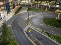 a street corner has two circular roads with no cars on it at night near a building