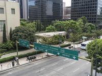 this city is looking over the intersection of a street sign and a bridge that leads to it