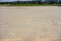 a cement parking lot with no grass around it in the day time and a clear blue sky