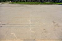 a cement parking lot with no grass around it in the day time and a clear blue sky