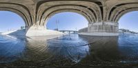 the view from a perspective looking at two large arches with water on either side and in the center