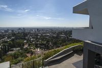 a view from an upstairs floor level home of los angeles skyline and pool with large windows and railings