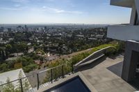 a view from an upstairs floor level home of los angeles skyline and pool with large windows and railings