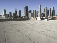 a wide view of a city skyline and a man with a skateboard in the foreground