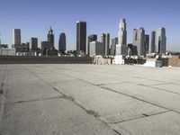 a wide view of a city skyline and a man with a skateboard in the foreground