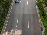 a highway with several empty lanes next to trees and buildings of various sizes are shown