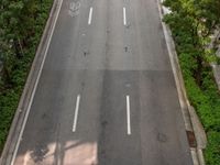 a highway with several empty lanes next to trees and buildings of various sizes are shown