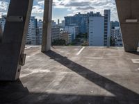 the sun is shining on buildings from under the underside of a bridge with a view of the city below