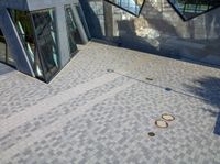 several buildings and two circle sculptures on the floor outside of a building's walkway