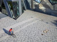 several buildings and two circle sculptures on the floor outside of a building's walkway