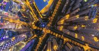 a night shot of skyscrapers from the sky looking down at city buildings on both sides