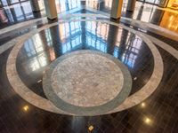 large marble floor in a lobby with windows in the background and an open space to showcase other buildings