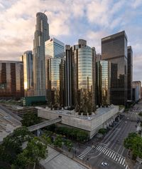 an aerial view of tall buildings in the city of los at sunrise, with traffic and cars traveling through the intersection