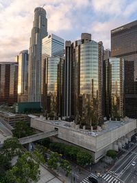 an aerial view of tall buildings in the city of los at sunrise, with traffic and cars traveling through the intersection