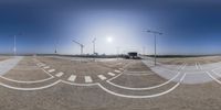 there are street lights that point towards an airport road with the runway in view behind them