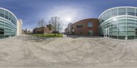 a spherical view of a public building and parking lot at dusk with no cars on the street