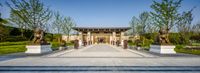 the entrance to the hotel has several statues outside it, along with a large courtyard