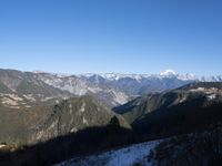 the view of mountains from the top of a mountain with cable car tracks and cable