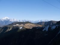 the view of mountains from the top of a mountain with cable car tracks and cable