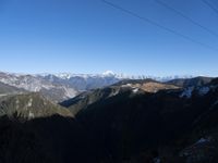 the view of mountains from the top of a mountain with cable car tracks and cable