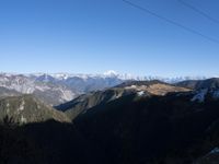 the view of mountains from the top of a mountain with cable car tracks and cable