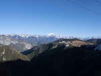 the view of mountains from the top of a mountain with cable car tracks and cable