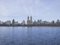 a view of the city from a distance from a lake in central park, new york
