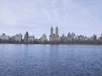a view of the city from a distance from a lake in central park, new york